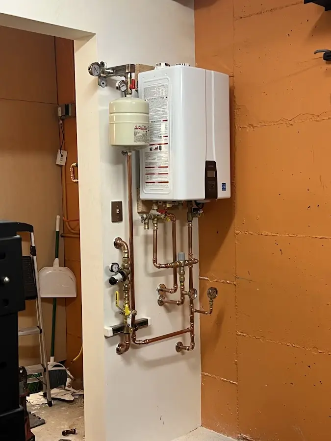 Plumbing technician inspecting water heater connections in East Peoria